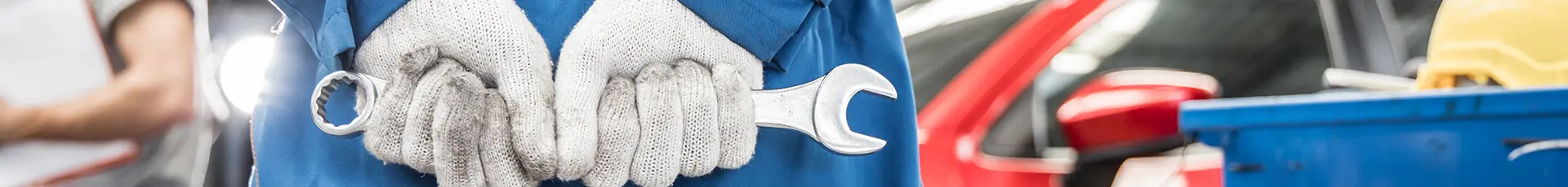 Mechanic in Blue Uniform Holding Wrench in Shop
